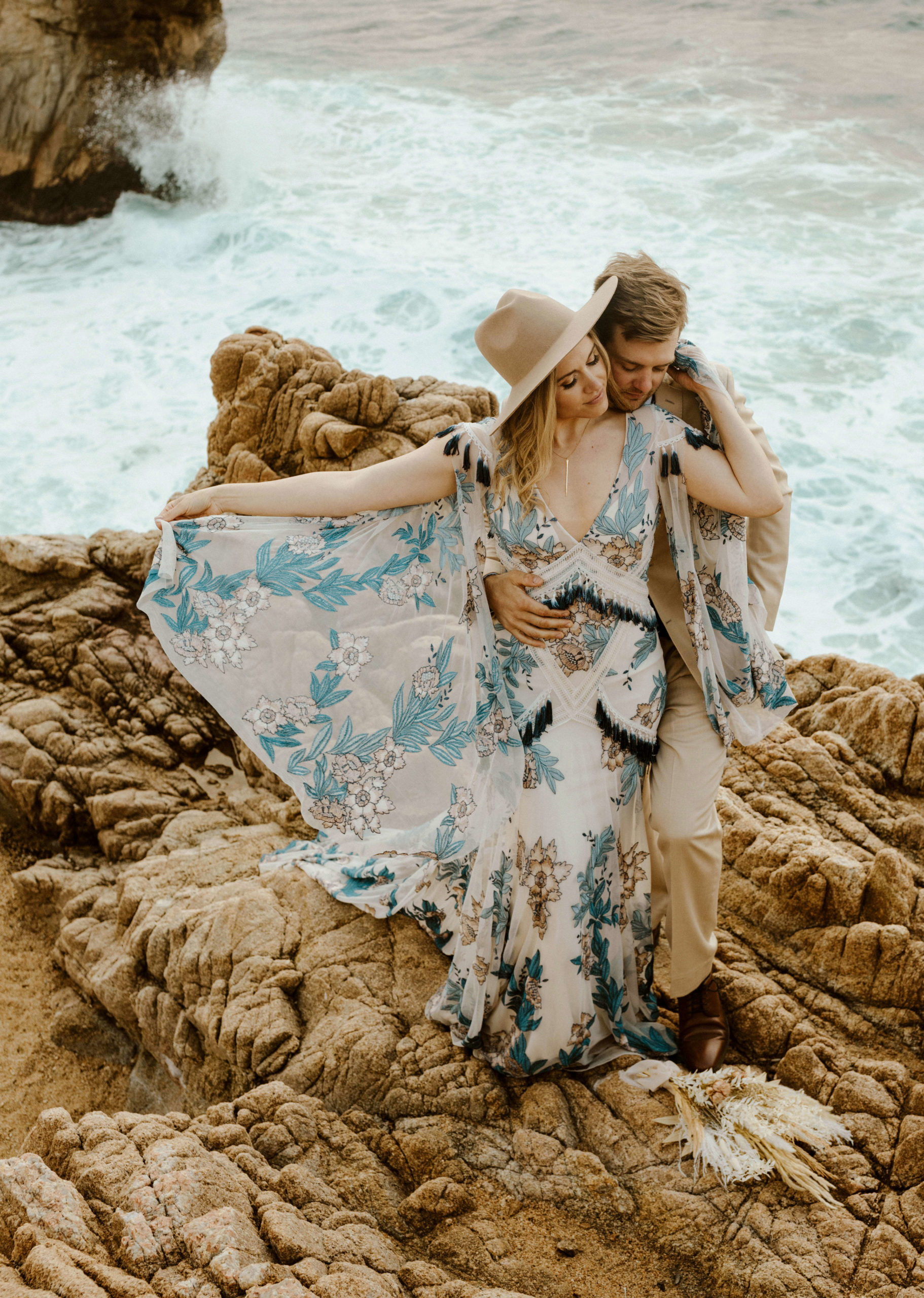 wedding couple cuddling on the rocks