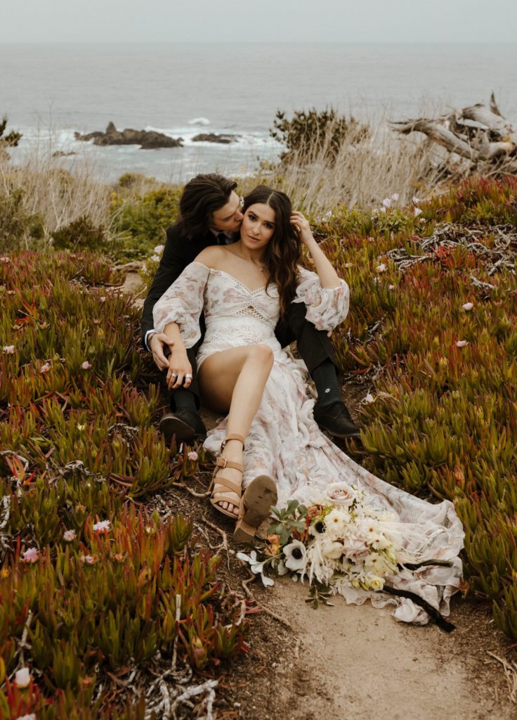 Wedding couple cuddling on the cliff in Big Sur