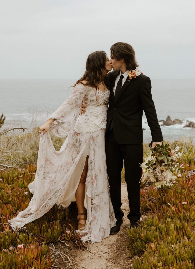 Wedding couple kissing and holding dress