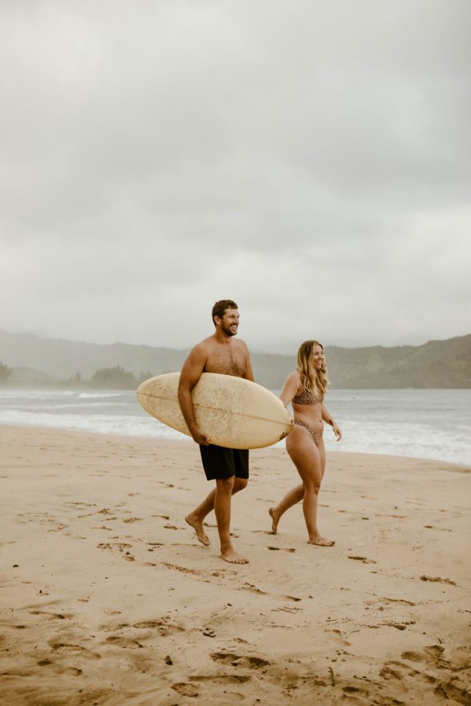 surf couple walking on the beach