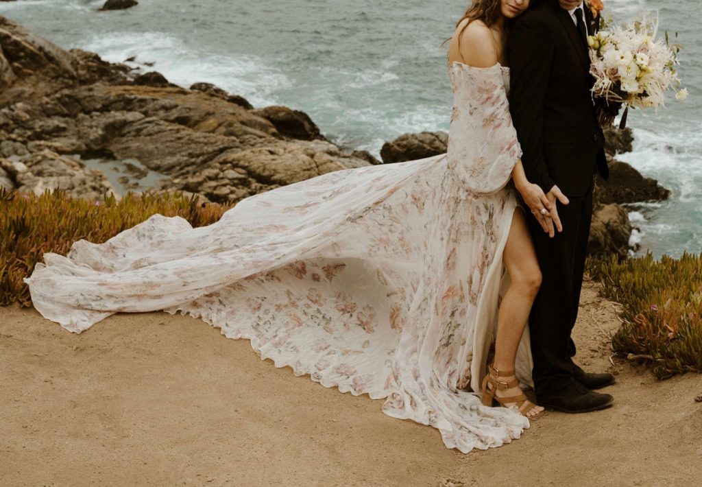 Wedding couple holding hands and dress blowing in the wind