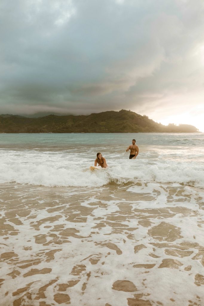 couple surfing in kauai