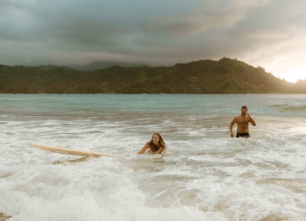 couple surfing in kauai