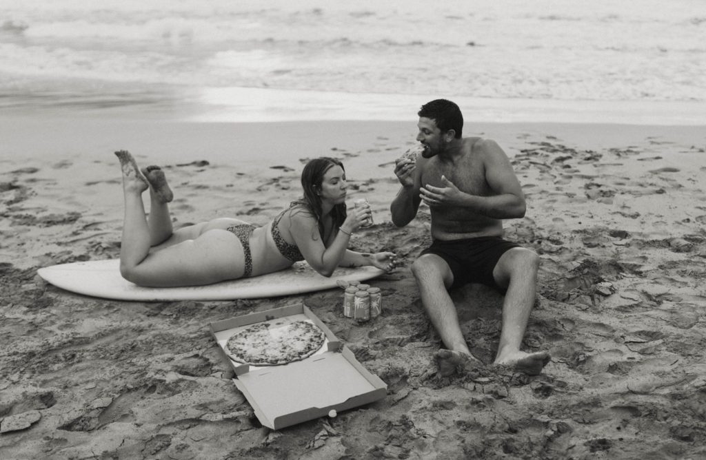 couple having pizza on the beach