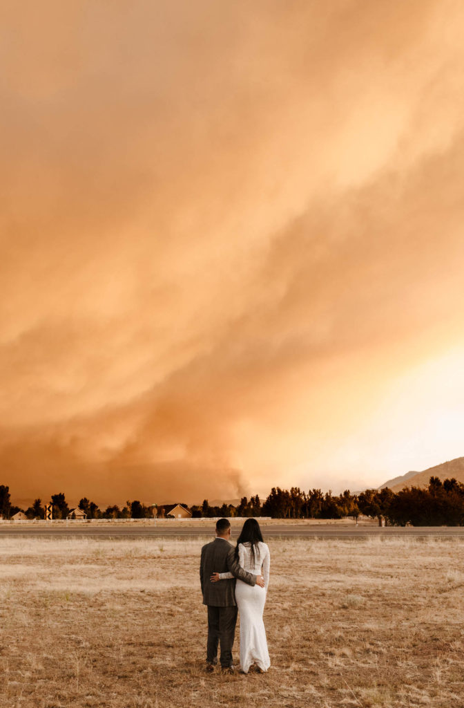 couple standing in front of a fire on their wedding day