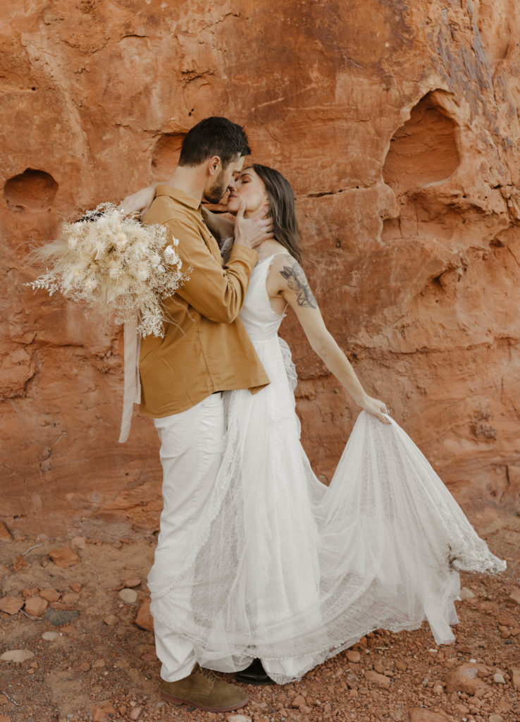 wedding couple kissing in front in the red canyons