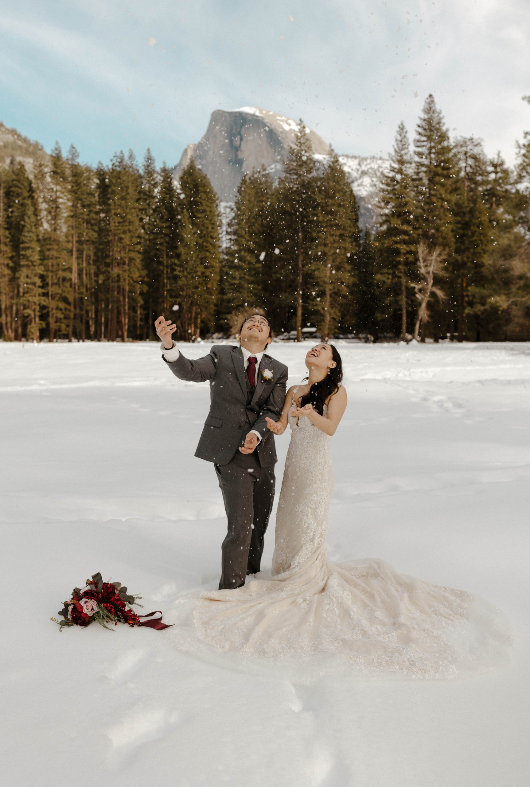 wedding couple throwing snow in the air in yosemite valley