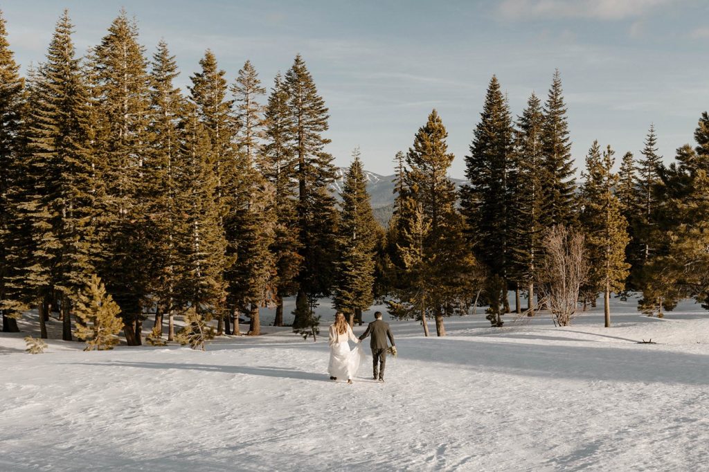 wedding couple hiking in the mountains in the winter