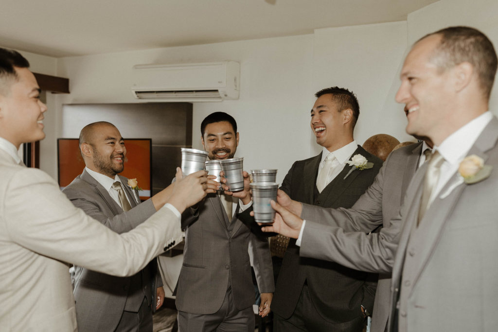 Wedding groom smiling while cheering drinks with groomsmen at the carmel highlands