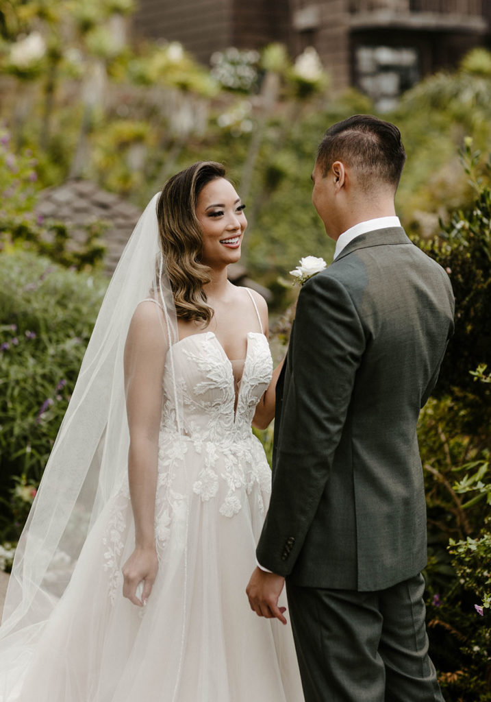 Wedding bride smiling at groom with greenery at carmel highlands
