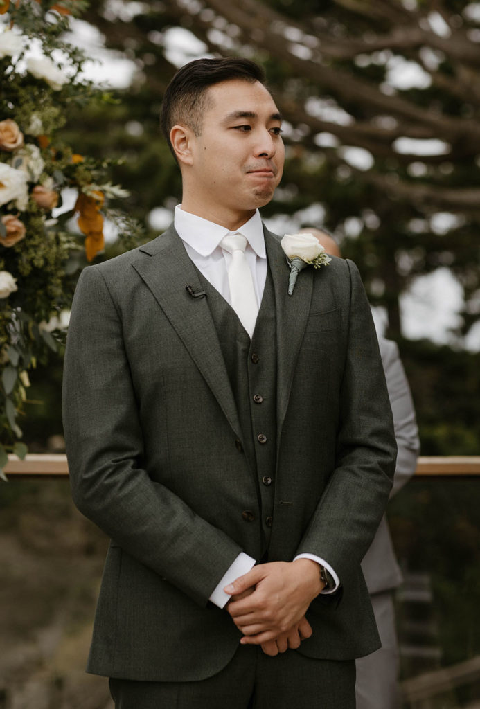 Wedding groom emotional while standing with hands clasped at wedding ceremony at carmel highlands