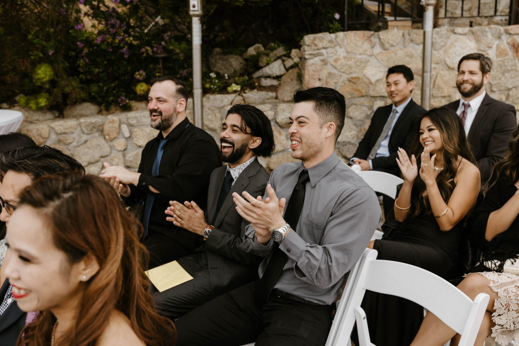 Wedding guests laughing and clapping during ceremony at carmel highlands