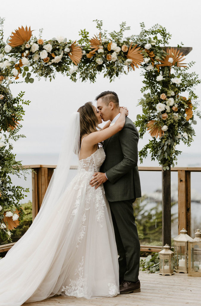 Wedding couple kissing with arms around each other after wedding ceremony at the carmel highlands