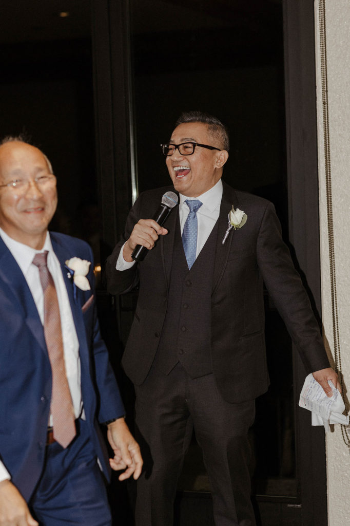 Wedding brides dad laughing while holding microphone during reception at carmel highlands