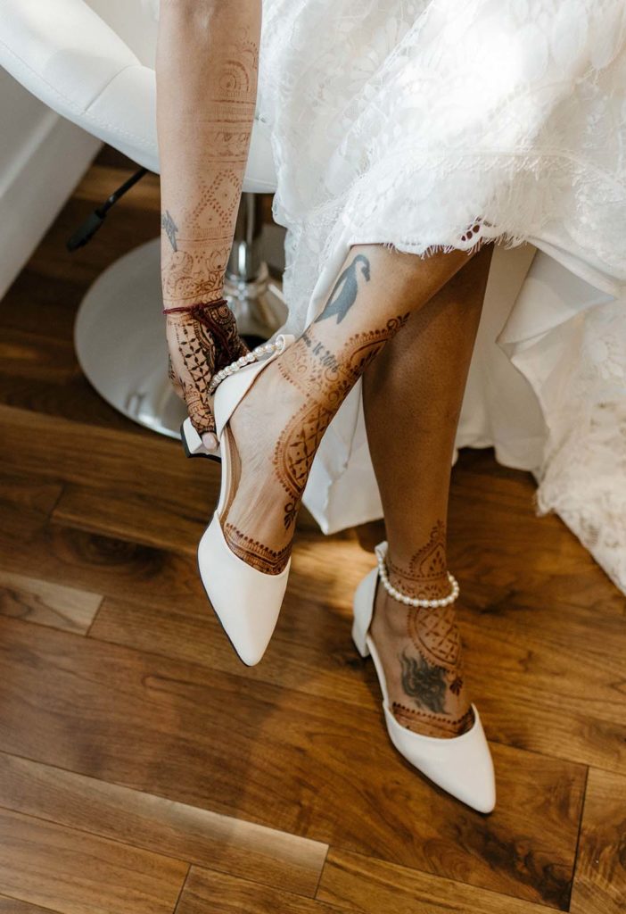 Wedding bride putting on wedding shoes with traditional markings at the elm estate