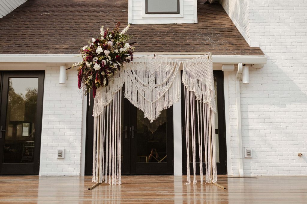 Wedding arch with crochet decorations outside at the elm estate