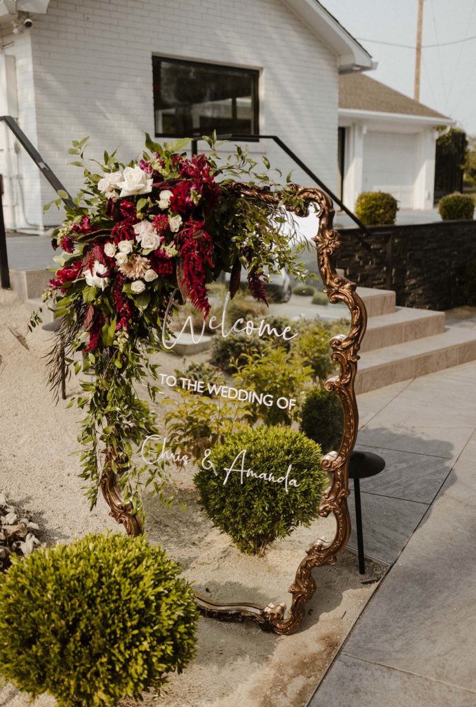 Reflective wedding welcome sign with floral decorations at the elm estate