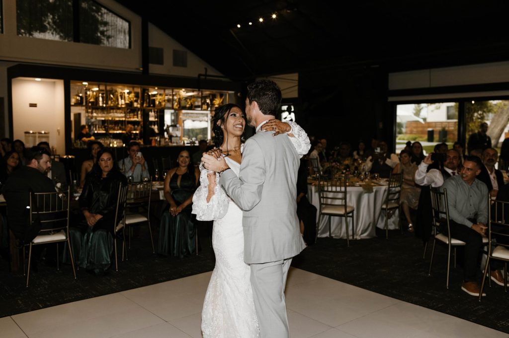 Wedding couple holding hands while dancing during reception at the elm estate