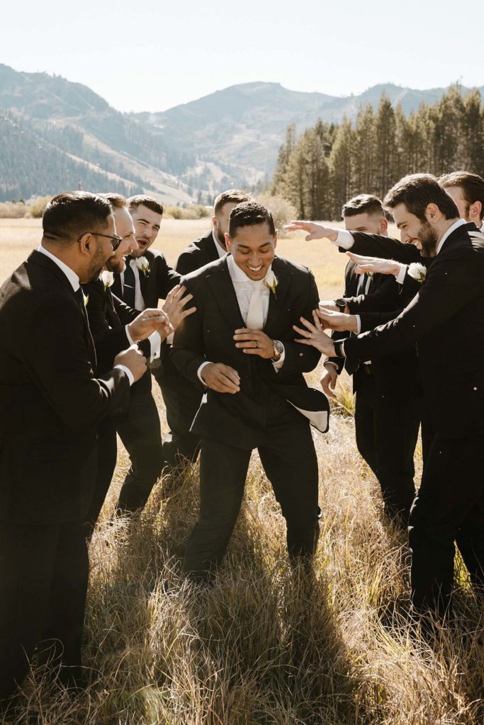 groomsmen laughing and pushing the groom at the resort at squaw creek