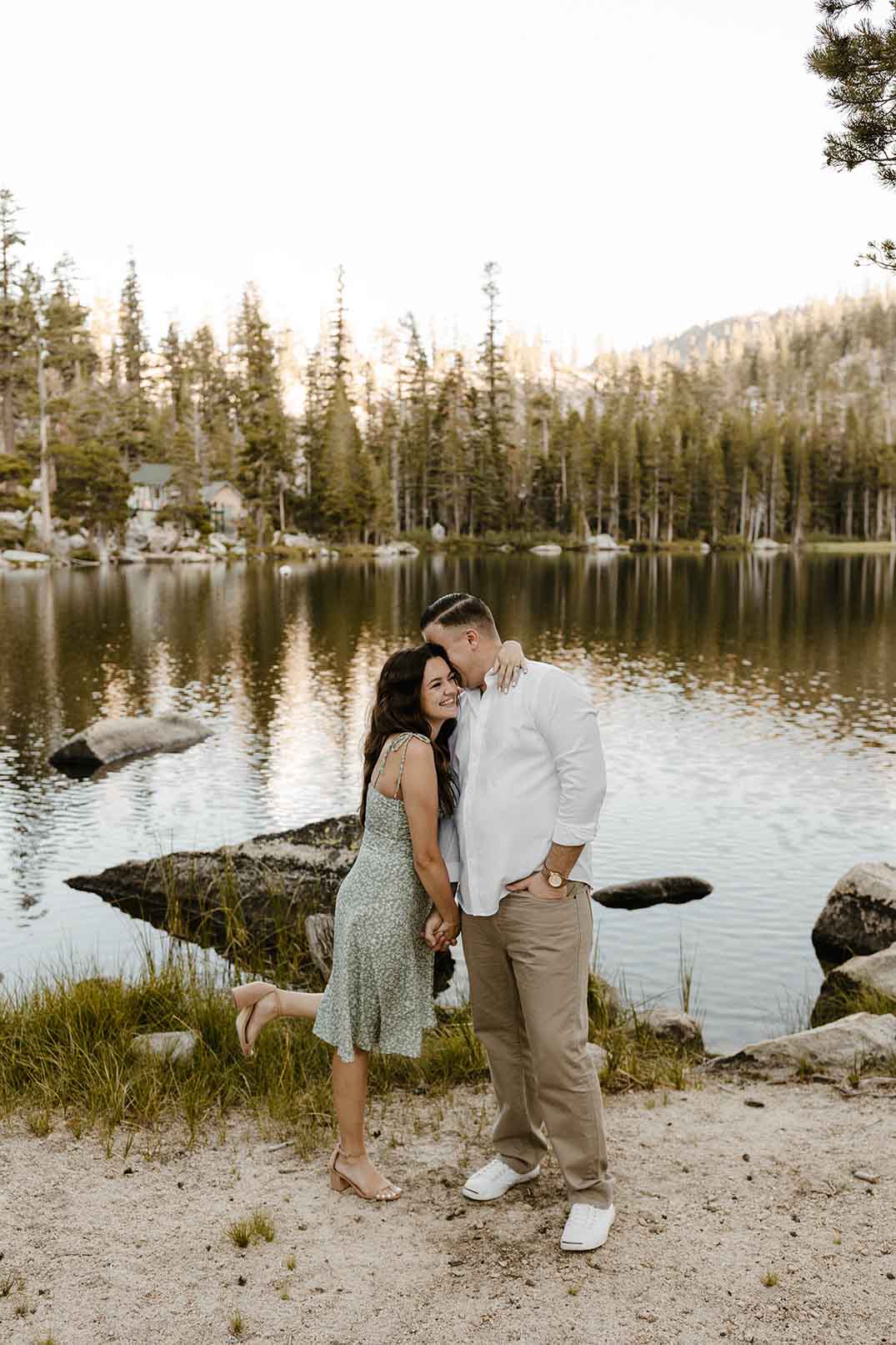 couple holding hands and smiling by lake tahoe