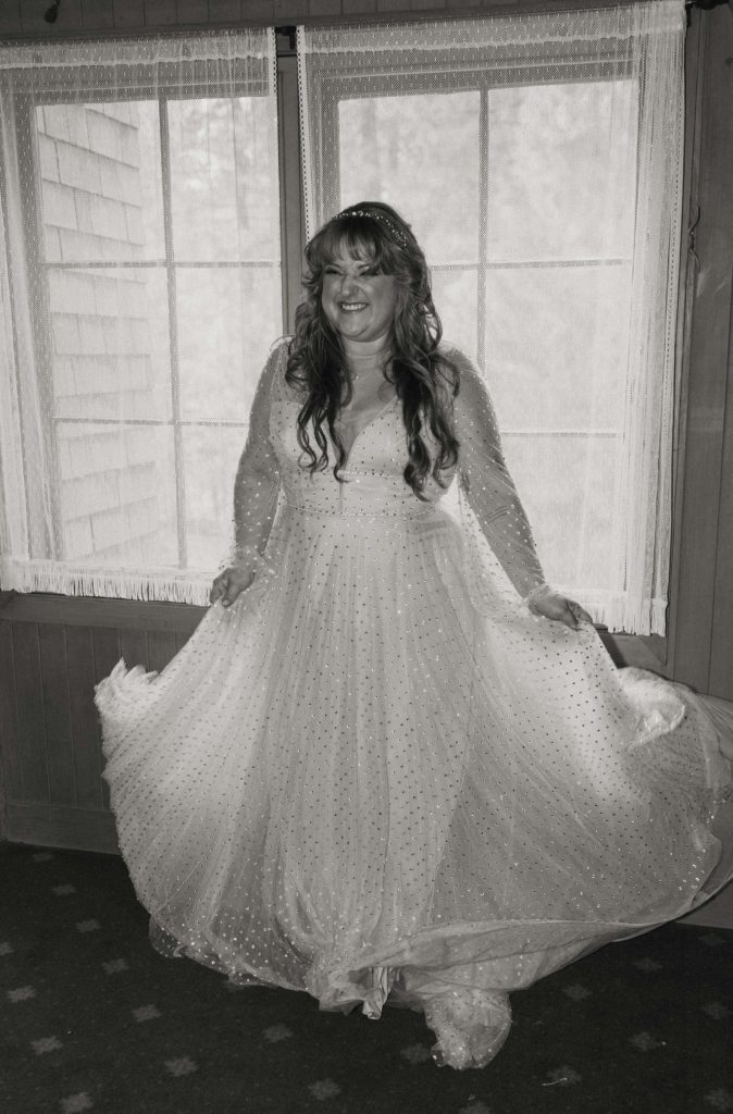 Wedding bride smiling while holding out dress sides inside in Lake Tahoe