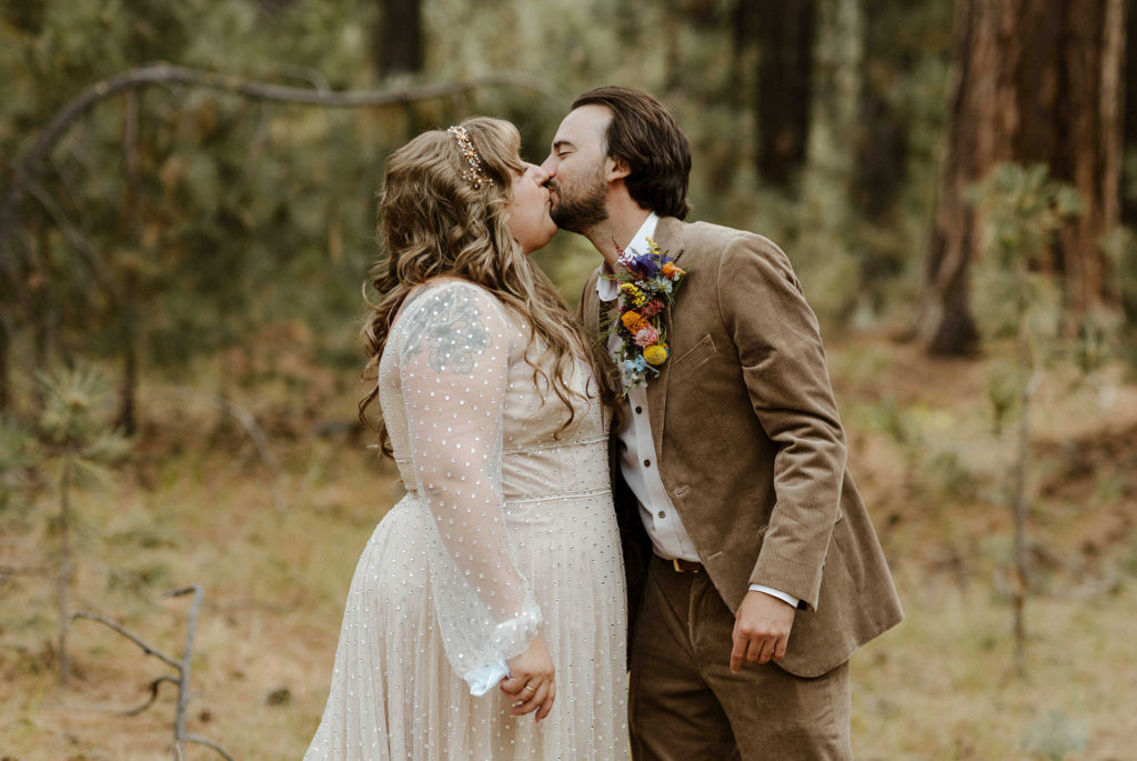 Wedding couple kissing while outside in forest in Lake Tahoe