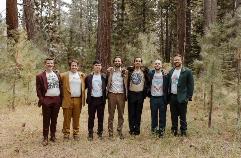 Wedding groom and groomsmen standing together with arms around each other smiling at camera in Lake Tahoe