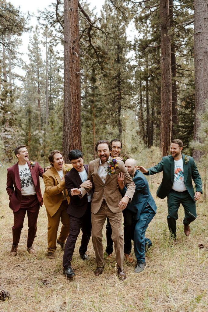 Wedding groom laughing as groomsmen chase and tackle him outside in Lake Tahoe