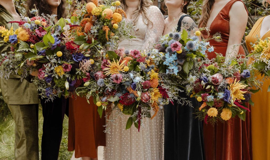 Close up of wedding bride and bridesmaids holding flower bouquets next to each other outside in Lake Tahoe
