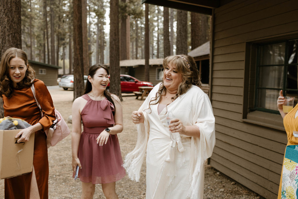 Wedding bride laughing with wedding guests while outside in Lake Tahoe