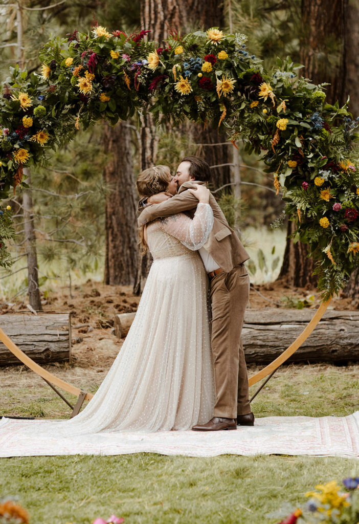 Wedding couple kissing in front of wedding arch after ceremony in valhalla in Lake Tahoe