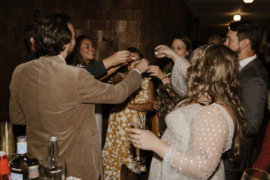 Wedding couple cheering shots with wedding guests during reception inside at valhalla in Lake Tahoe