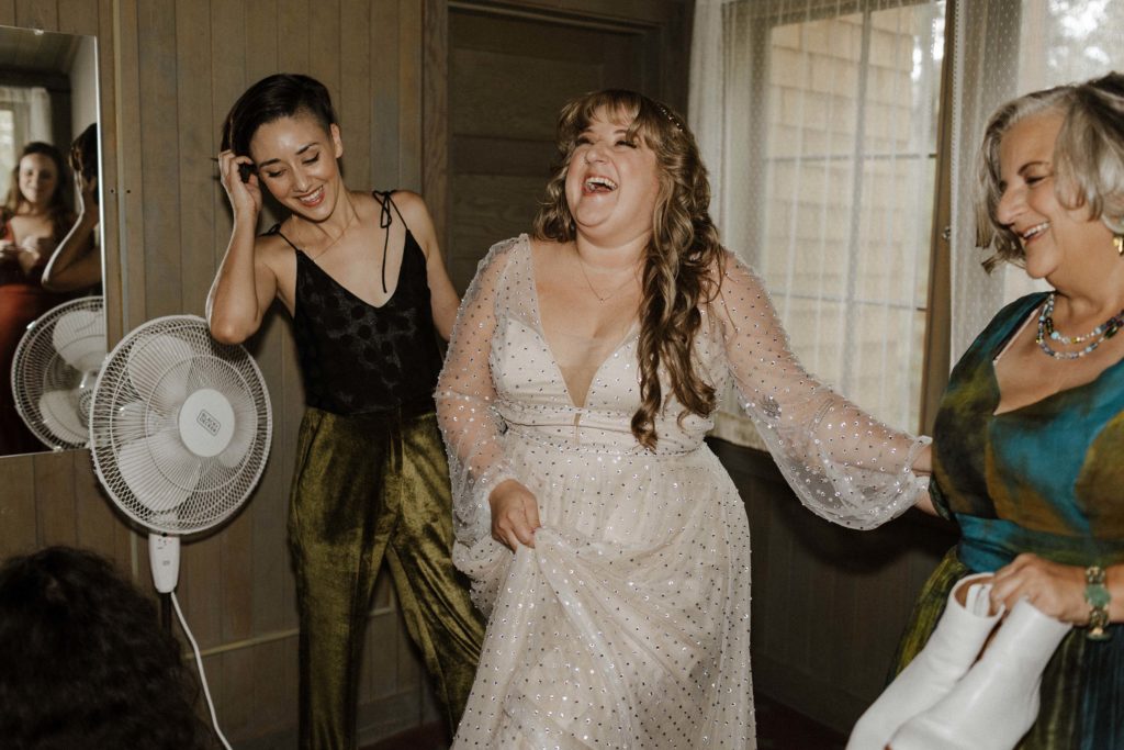 Wedding bride laughing with mom and bridesmaid while getting ready in Lake Tahoe