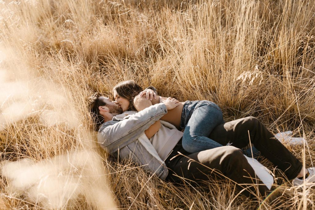 couple laying in a meadow in lake tahoe for their engagement photos