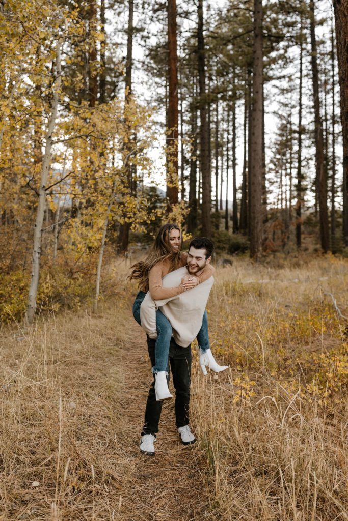couple having a piggy back ride in the forest in lake tahoe