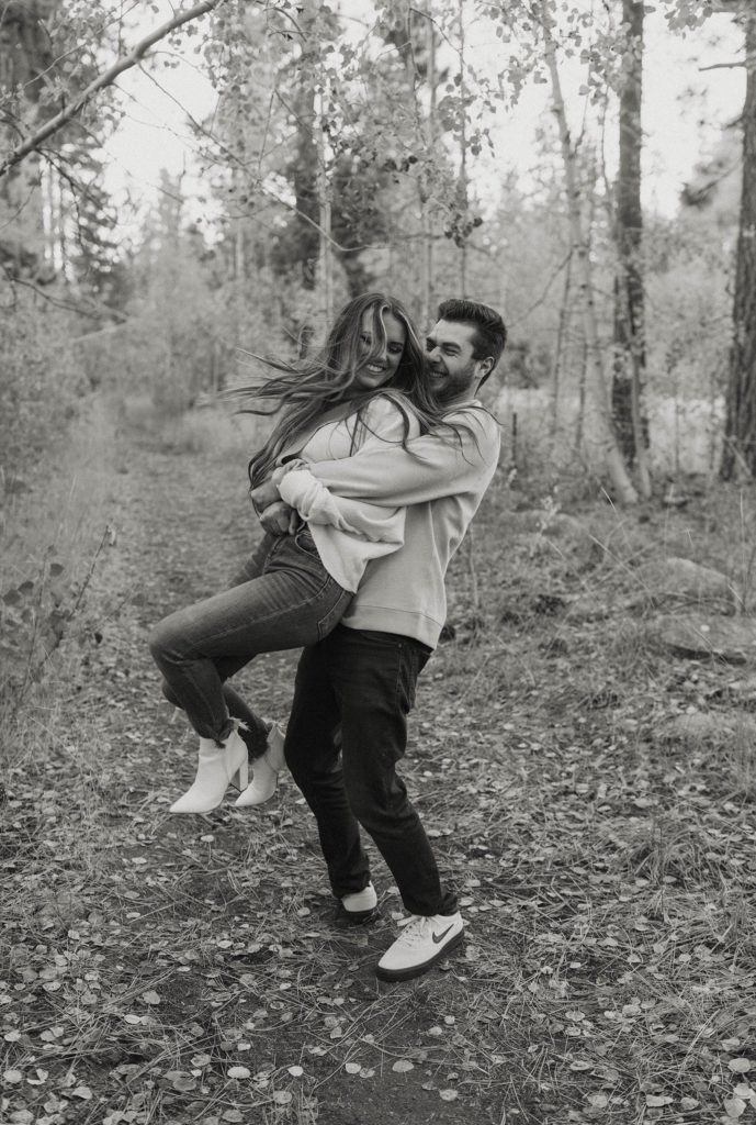 man spinning woman around in his arms in lake tahoe