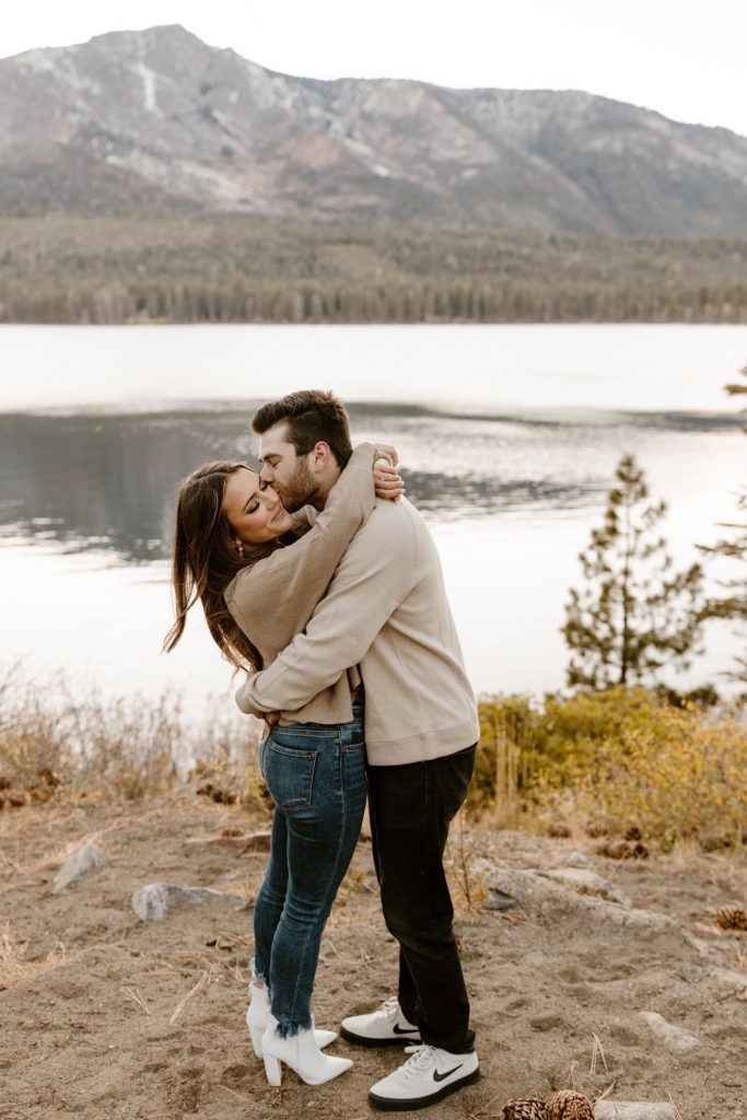 couple hugging overlooking the lake for their engagement photos