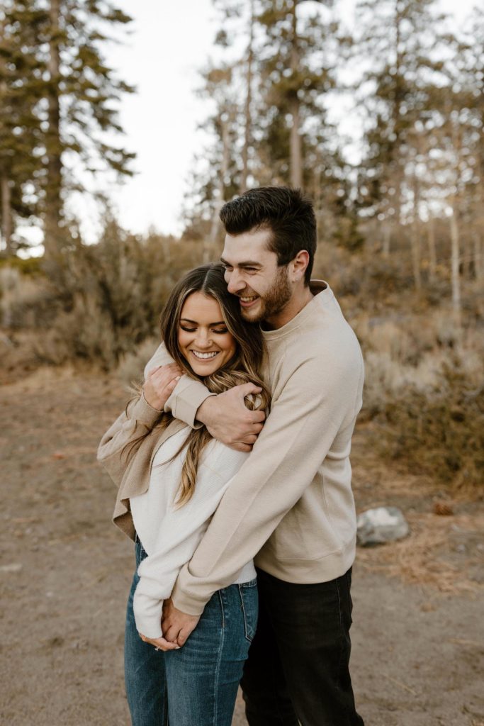 couple hugging and laughing in lake tahoe for their engagement photos