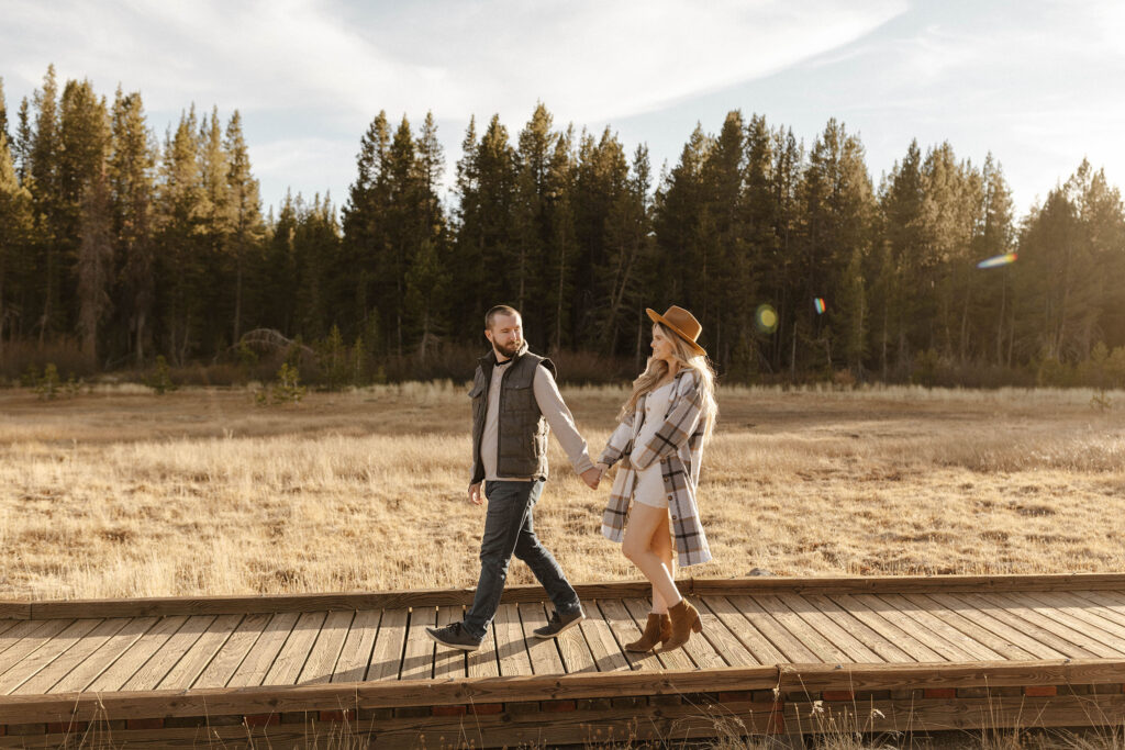 pregnant couple walking in a meadow in lake tahoe
