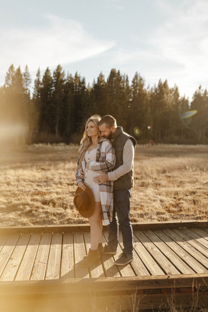 couple hugging and holding belly in lake tahoe