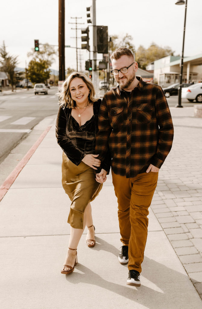 couple walking and smiling together on a sidewalk in reno