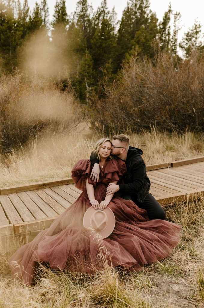 man kissing woman's cheek in a meadow in lake tahoe for their engagement photos