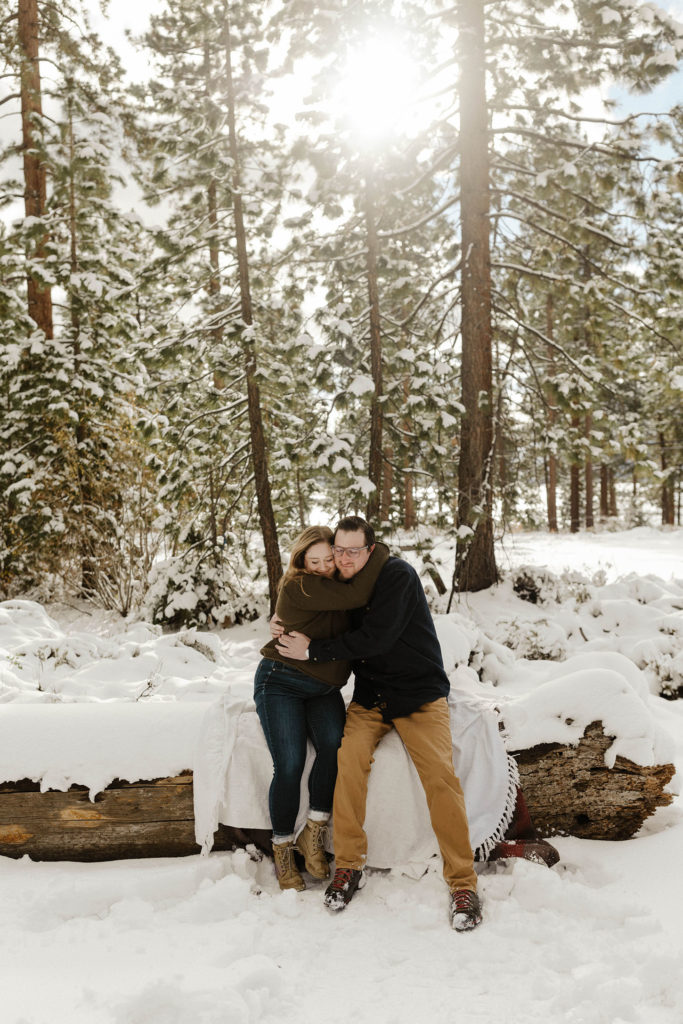 couple hugging with a blanket for their winter lake tahoe engagements