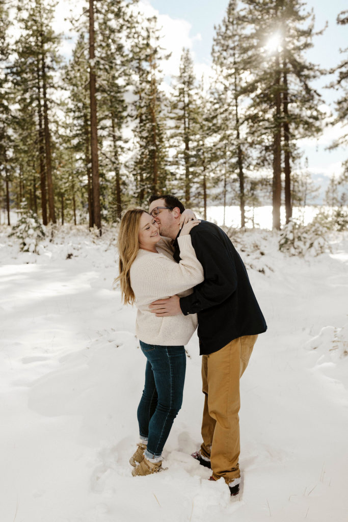 couple kissing in the snow their winter lake tahoe engagements