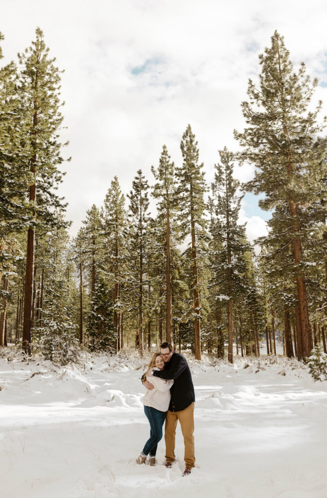couple hugging in the snow for their winter lake tahoe engagements