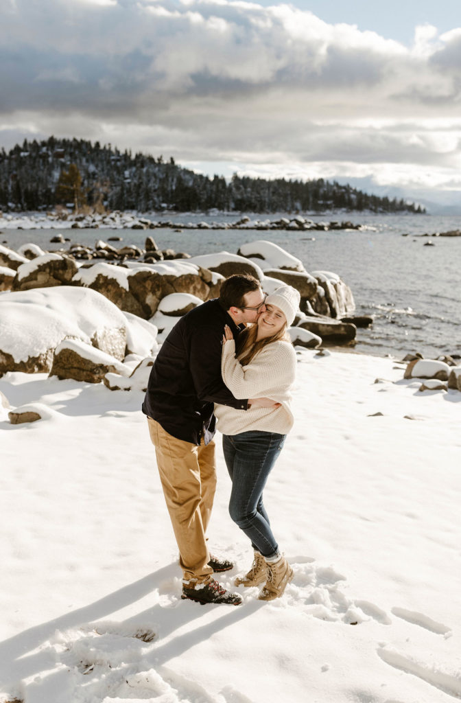 couple hugging on the beach in lake tahoe in the winter