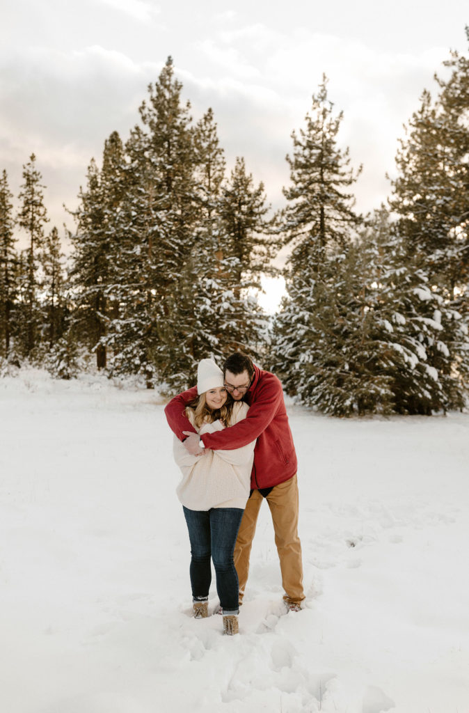 couple hugging in the snow in lake tahoe in the winter