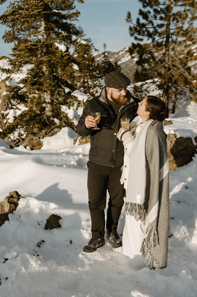 elopement couple smiling while holding hot drinks in lake tahoe
