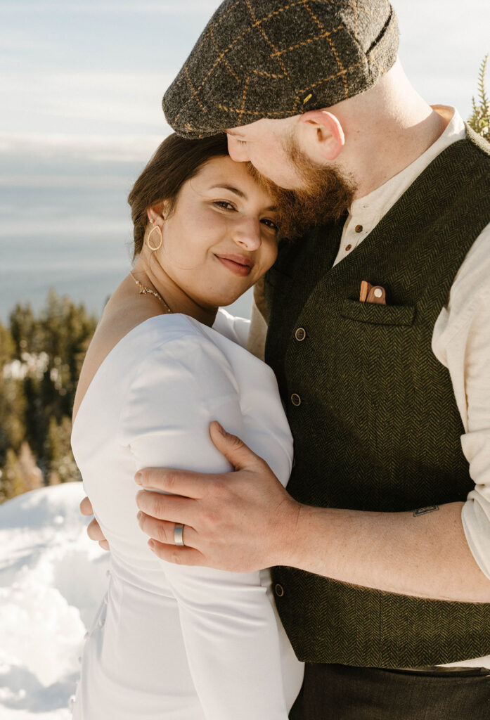 bride smiling as groom kisses her forehead in lake tahoe