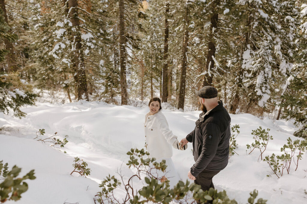 elopement couple walking in the snow in lake tahoe